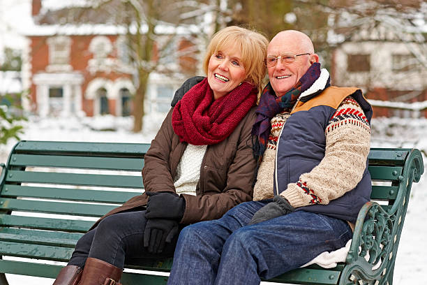 istock Happy senior couple sitting on a park bench 180749170