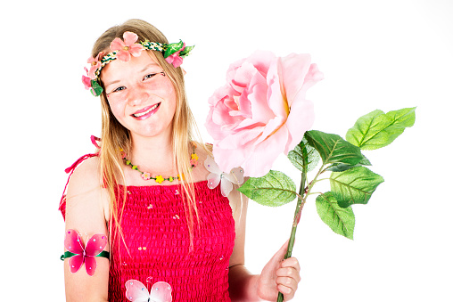 Girl dressed as a fairy with a big pink flower.