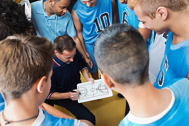 istock High school basketball coach explaining play to team 180751899