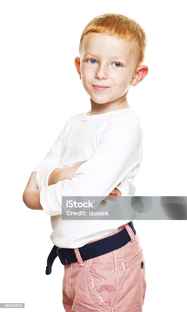 Cute Boy Smiling Portrait of cute little boy standing with crossed arms and smiling at the camera. Studio shot, isolated on white. Boys Stock Photo