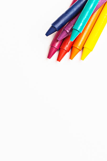 istock Multicolored wax crayons in corner of white sketchpad 180752232