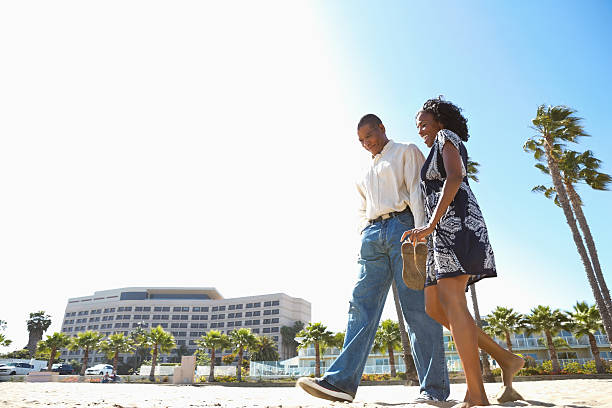 istock African American couple holding hands while walking on the beach. 180752662