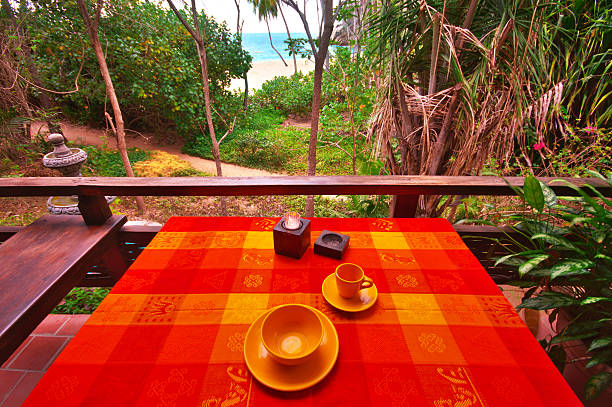 Tropical Table Setting on Majahuitas Beach "An early morning table stting overlooking the palm trees of Majahuitas Beach and across the Bay of Banderas to Puerto Vallarta, Mexico.All images in this series..." majahuitas beach stock pictures, royalty-free photos & images