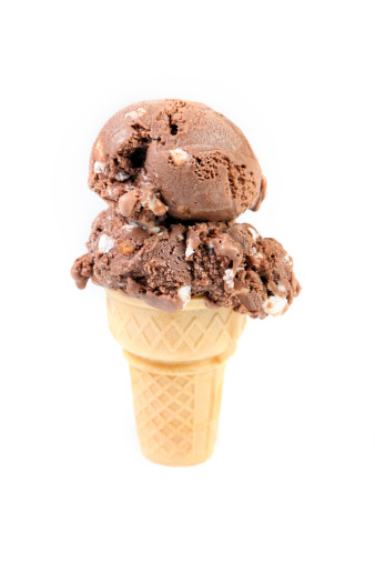 Scoops of Rocky Road ice cream on a plain cone.