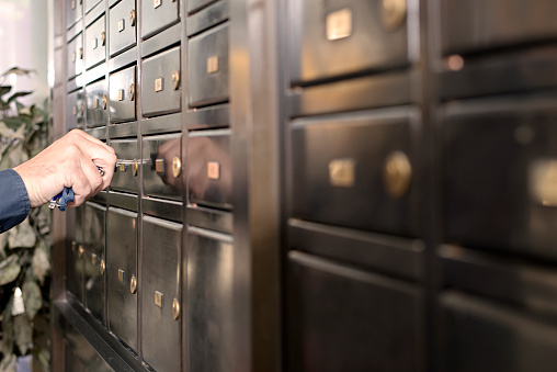 Man opening safety deposit box with a key.