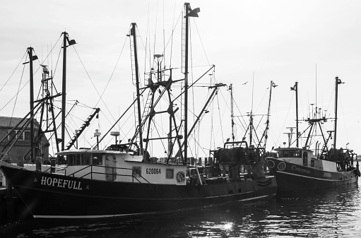 Amagansett, Rhode Island, USA - 27 June 2021: A black and white photo of several fishing boats in the water
