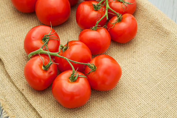 istock Fresh organic tomatoes on brown burlap 180755145