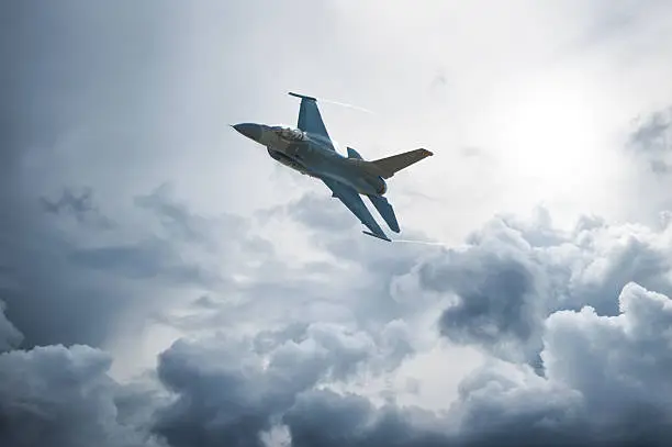 An F-16 climbs in altitude as it soars above the clouds.