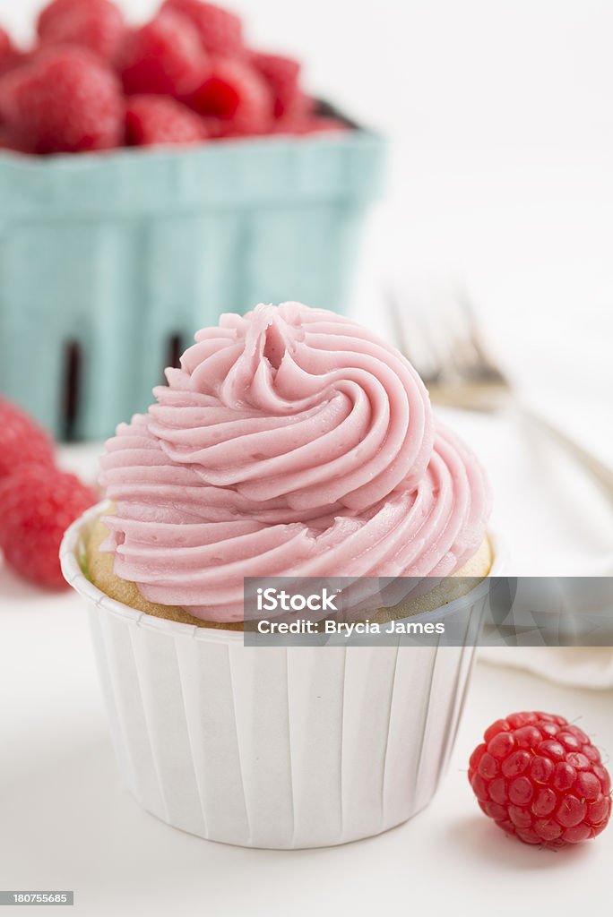 Raspberry Cupcake with Pint of Berries Raspberry cupcake with a pint of raspberries in the background. Baked Stock Photo