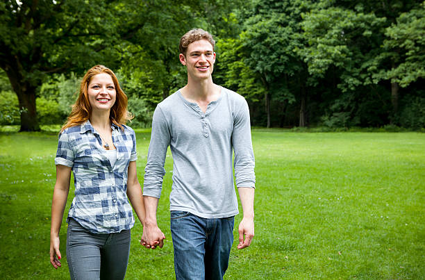 istock Romantic young couple walking in park 180755716