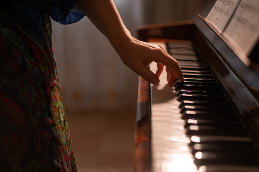 a woman plays the piano. selective focusing. High quality photo