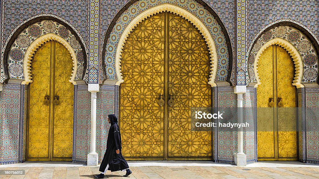 Moroccan man walking in front of The Royal Palace, Fes "Moroccan man walking  in front of The Royal Palace, Fes, Morocco." Morocco Stock Photo