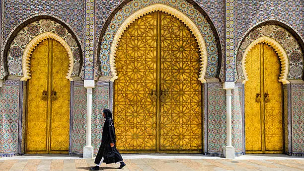 "Moroccan man walking  in front of The Royal Palace, Fes, Morocco."