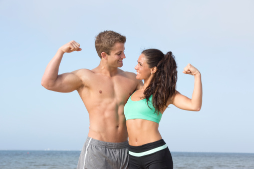 fit couple flexing on the beach
