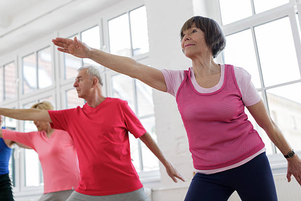 istock Senior adults with arms outstretched in yoga pose 180758464