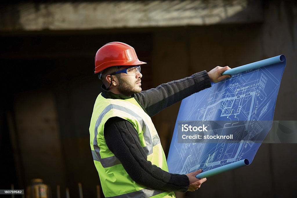 Travailleur de la Construction contrôle un bâtiment site - Photo de 20-24 ans libre de droits