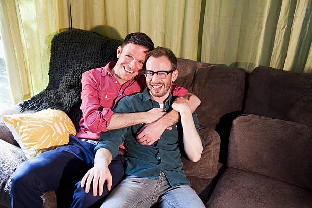 istock Gay couple  sitting on couch 180759750