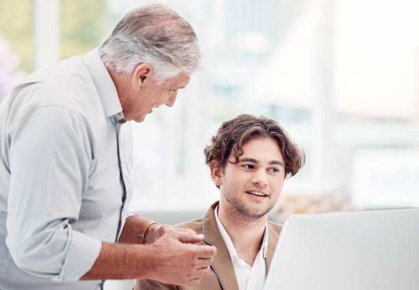 Help, coaching and man with manager at computer at tech startup with team leader and quality assurance for staff. Businessman, management and leadership helping at creative agency or digital industry