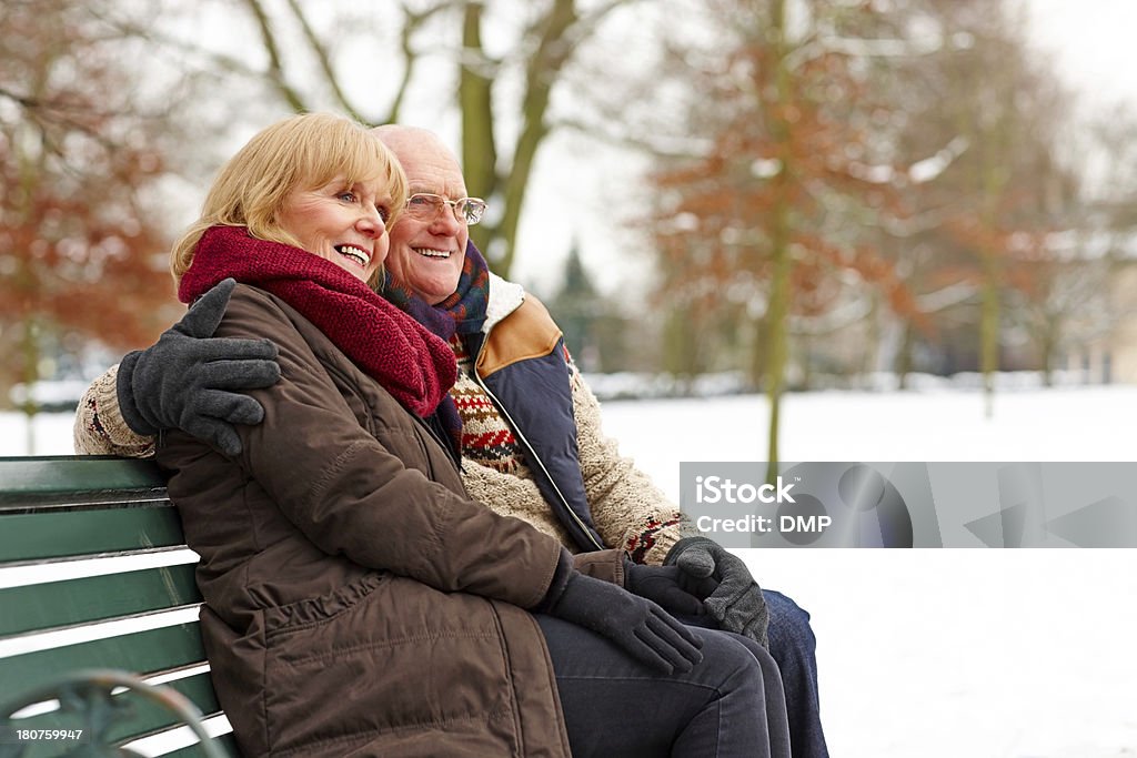 Personnes âgées couple assis sur un banc au parc de neige - Photo de Hiver libre de droits