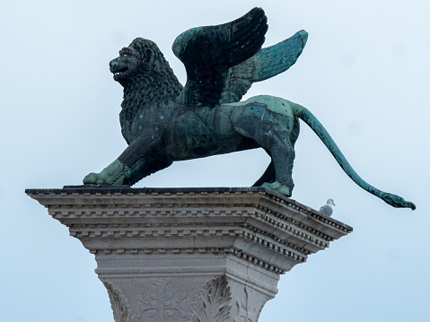 Venice, Italy - November 1 2023: Detail of San Marco column. The sculpture Lion of Venice surmounts Column of the Lion, symbolising Saint Mark the Evangelist.