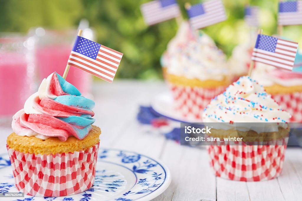Cupcakes avec rouge-Blanc et bleu glaçage et drapeaux américains sur table d'extérieur - Photo de 4 juillet libre de droits