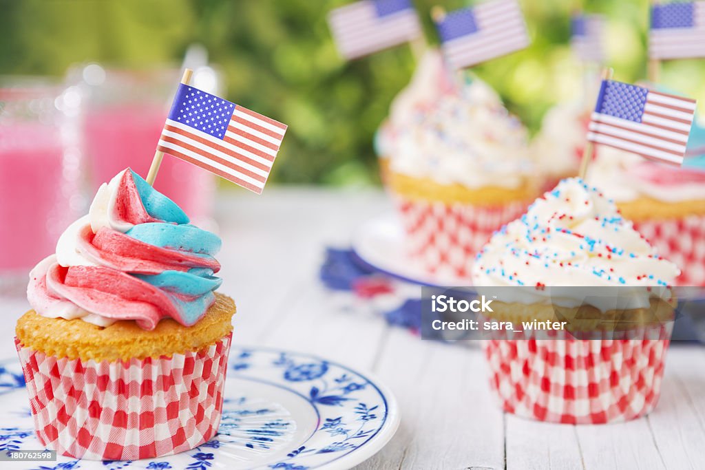 Cupcakes com vermelho, branco e azul frosting e bandeiras da América na mesa ao ar livre - Royalty-free 4 de Julho Foto de stock