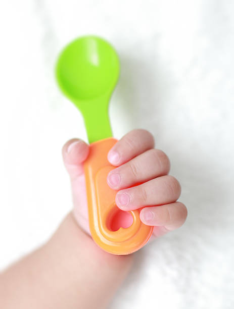 baby hand baby hand baby spoon stock pictures, royalty-free photos & images