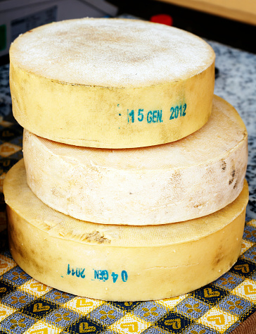 Ascona, Switzerland - August 23, 2016: Typical italian Parmigiano Reggiano cheese head on the counter in Ascona street market, Lake Maggiore, Ticino canton, in Switzerland.