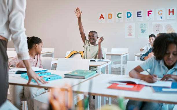 istock Question, school and education with a black boy student hand raised in a classroom to ask or answer his teacher. Kids, asking and learning with a young male child in class to study for growth 1807673859