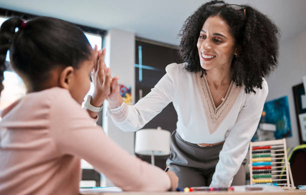 istock High five, success or teacher in celebration with a student in a classroom with learning development. Goals, education or happy black woman smiles teaching or celebrates a target with a school girl 1807674383