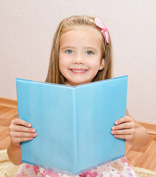 istock Cute little girl reading a book 180767579