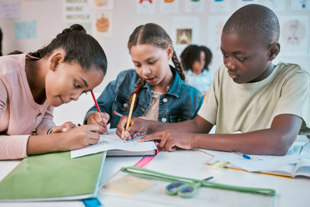 istock Teamwork, education, and group of children in classroom working together on project in Montessori school. Books, help and diversity, young students writing or drawing in notebook for fun art homework 1807676730
