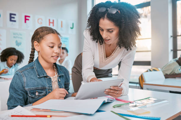 istock Education, tablet or girl students with teacher for ebook learning, assessment idea or scholarship research. Consulting, school or kid in classroom for information help, collaboration or search 1807678376