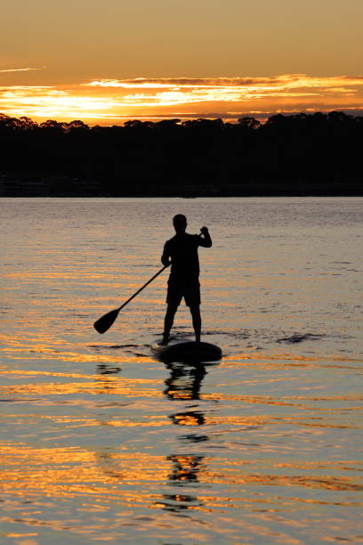 istock Stand up paddle board silhouettes at sunset 1807684136