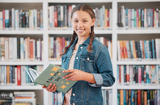 Portrait, books or girl reading in library for knowledge, education or development for future growth. Scholarship, focus or young student with a happy smile studying or learning information at school