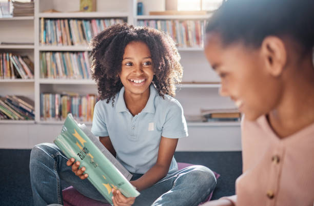 istock Library, reading and happy, african children learning, education and English language for group development. Books, knowledge and school or classroom kid or friends for creative storytelling on floor 1807684677