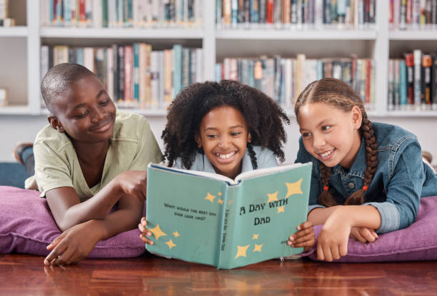 istock Children in library, reading book and learning, education and  story for academic growth, happiness with friends. Knowledge, information and development, young students happy to learn and school 1807684697