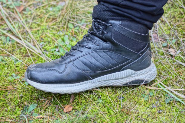 istock oga man in a black leather sneaker stands on green moss 1807705160
