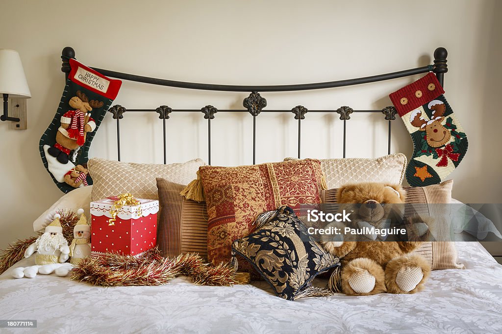 Bed covered with Christmas decorations Cozy Christmas bedroom scene with Christmas stockings on bedstead Bed - Furniture Stock Photo