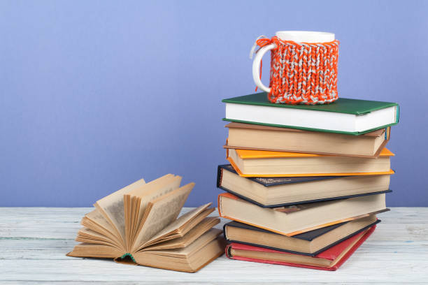 istock Book stacking. Open book, hardback books on wooden table and blue background. Back to school. Copy space for text. 1807729757