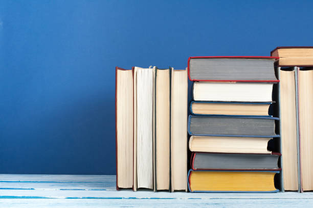 istock Book stack, hardback colorful books on wooden table and blue background. Back to school. Copy space for text. Education concept. 1807730277