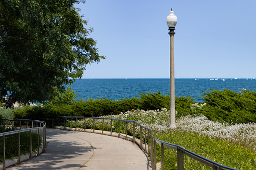 A beautiful landscape of the Chicago Lakefront trail with no people and curving along Lake Michigan during the summer