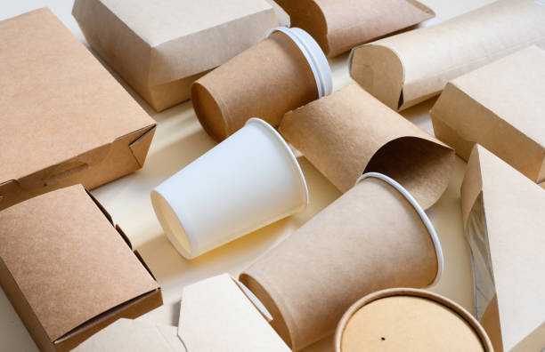 istock Lots of disposable paper tableware and packaging. Side view. Selective focus on white disposable paper cup. Eco-friendly packaging 1807731967