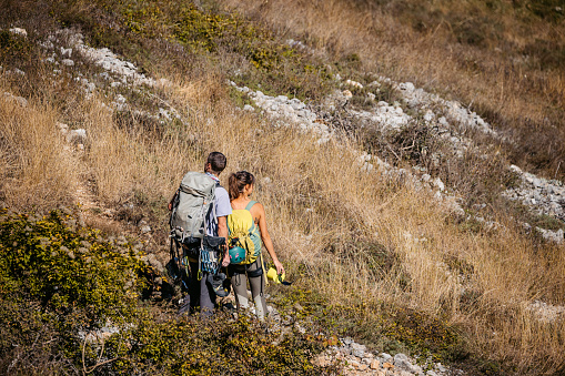 Young couple climbing a mountain.