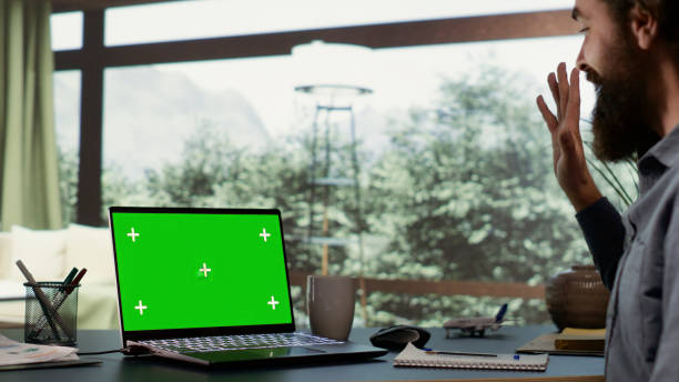 istock Rich businessman looks at greenscreen on pc 1807739334