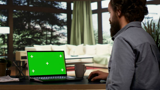 istock Young millionaire checks greenscreen template on laptop 1807740414