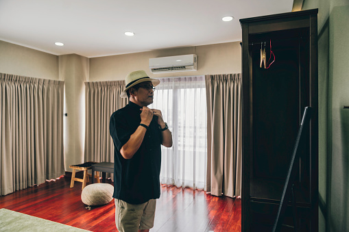 senior man choosing clothes from wardrobe at home