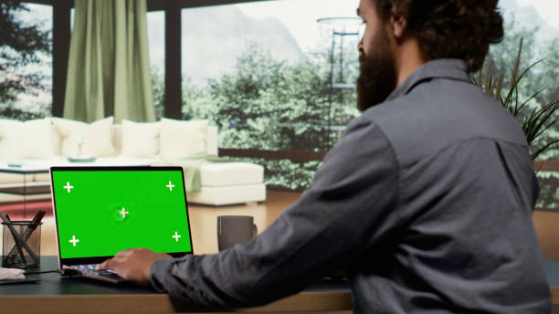 istock Businessman looks at greenscreen template on pc 1807748983