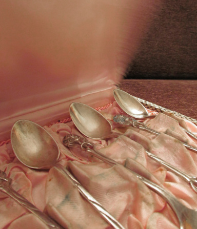 Antique silver teaspoons with rose handles in snake  print case, with pink satin lining.