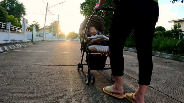Mother Walking with a child in a stroller at Park